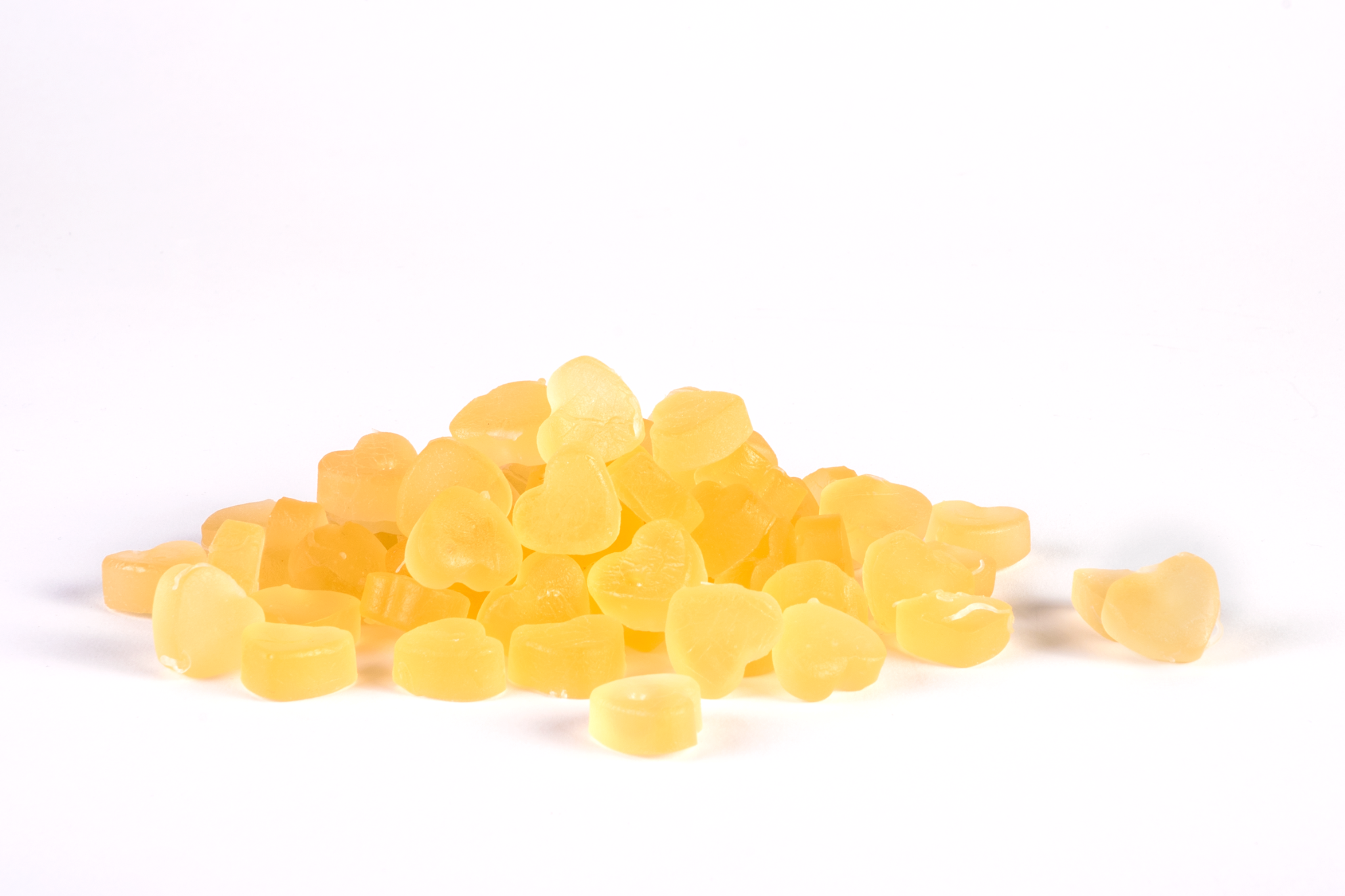 Close-up delle gomme masticabili Gummyvit Vitamin D, evidenziando la loro forma invitante e il colore che richiama la luminosità e il calore solare, simbolo dell'origine naturale della vitamina D